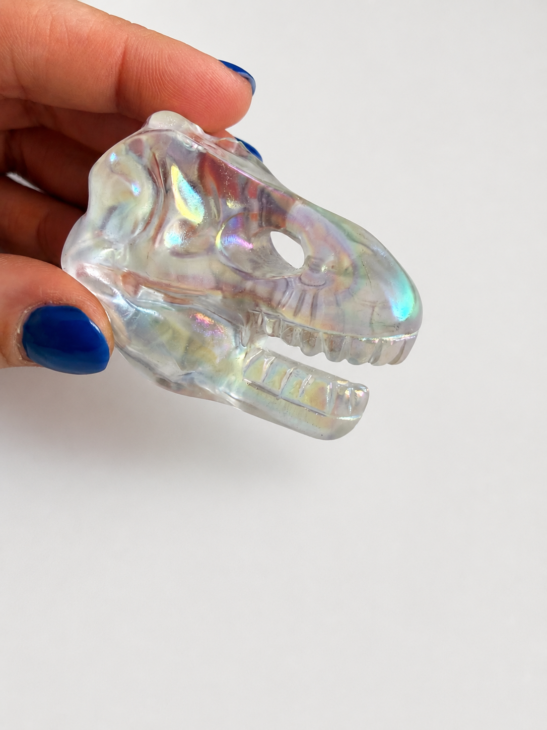 Aura coated clear quartz dinosaur skull carving